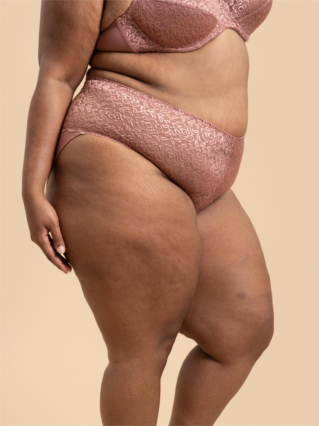 Person wearing pink lace lingerie on a beige background