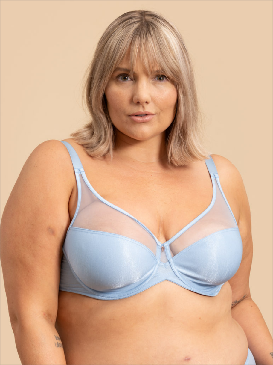 Woman wearing a light blue bra against a beige background