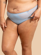 Light blue underwear worn by a person on a beige background
