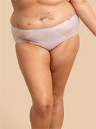 Person wearing light pink underwear on a beige background