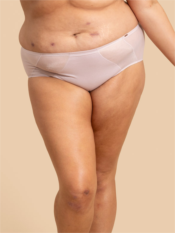 Person wearing light pink underwear on a beige background