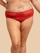 Person wearing red underwear on a beige background