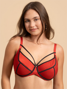 Woman wearing a red bikini top with black straps against a beige background