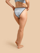 Person wearing light blue underwear on a beige background