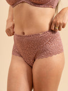 Lace underwear worn by a person on a beige background