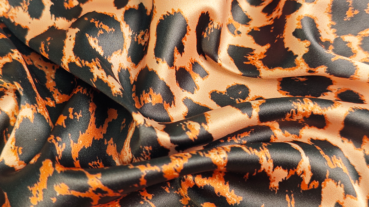 Close-up of MUSE leopard-print satin fabric.