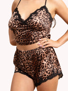Leopard print lingerie set with black lace trim on a beige background